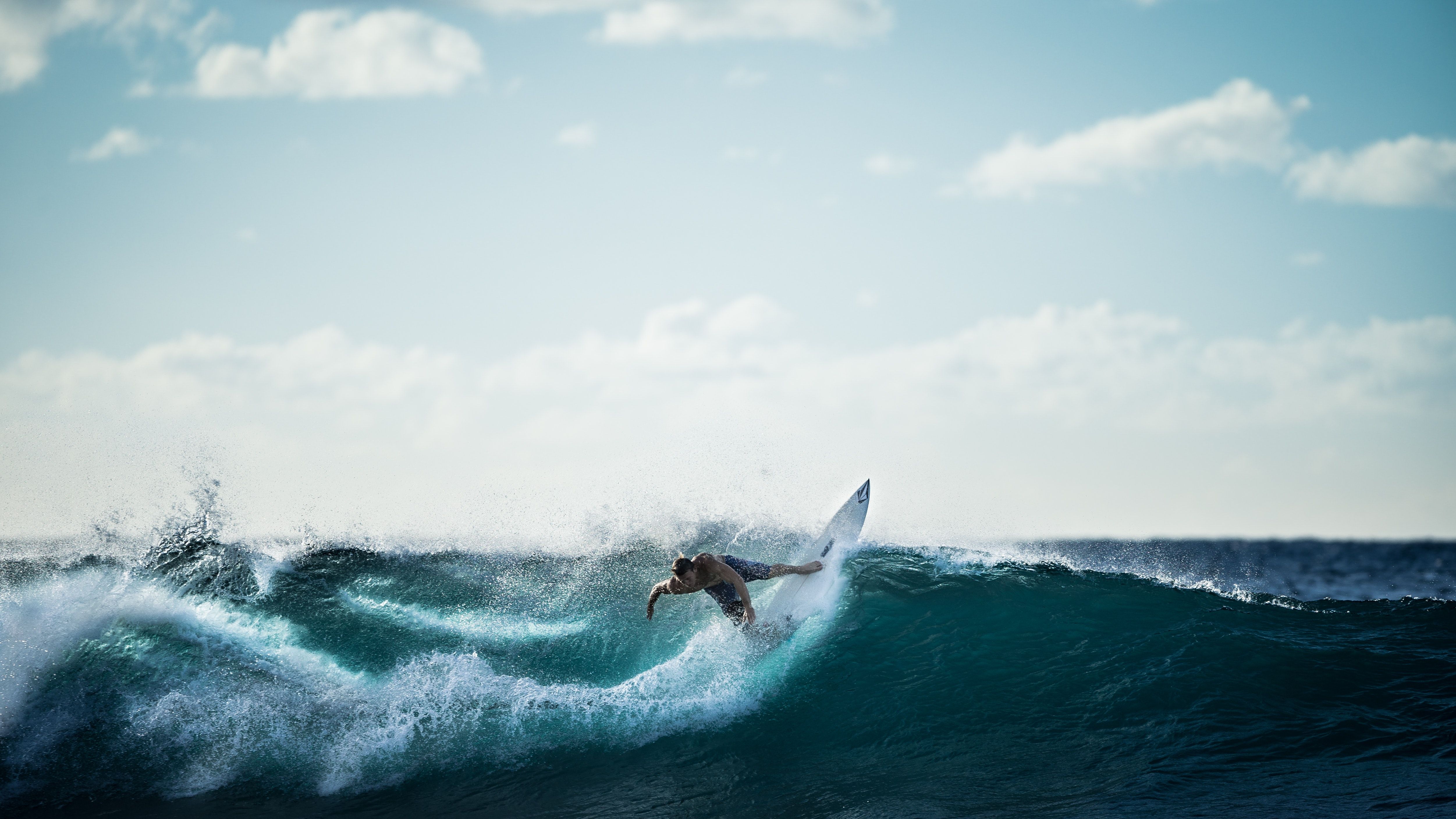 Persona que monta en la tabla de surf blanca Haciendo surf · Foto de archivo libre de regalías